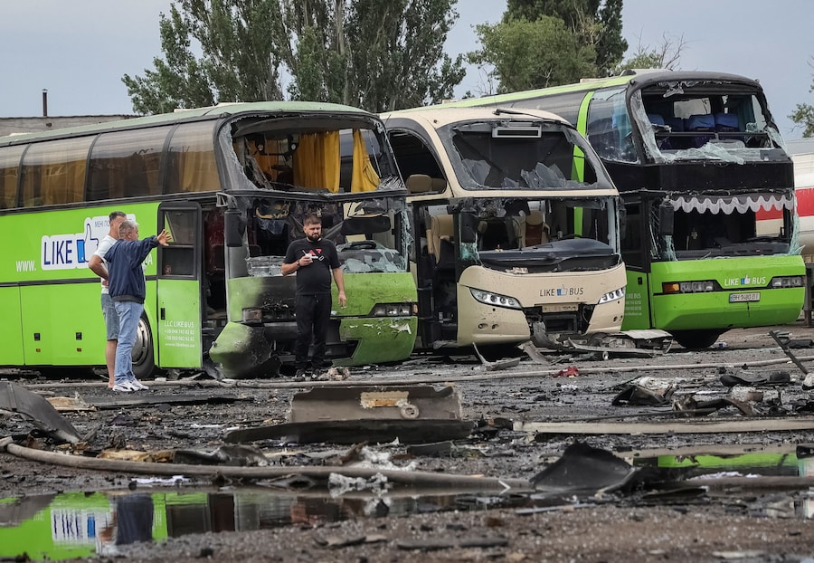 Alcune persone si trovano sul luogo in cui un parcheggio per autobus è stato colpito da un attacco con droni russi, nel contesto dell'offensiva russa contro l'Ucraina, a Odessa, Ucraina. (REUTERS)