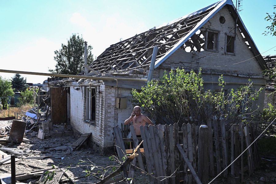 Un uomo reagisce mentre parla al cellulare, accanto alla sua casa danneggiata da un attacco aereo russo, nel contesto dell'offensiva russa contro l'Ucraina, a Zaporizhzhia. (REUTERS)