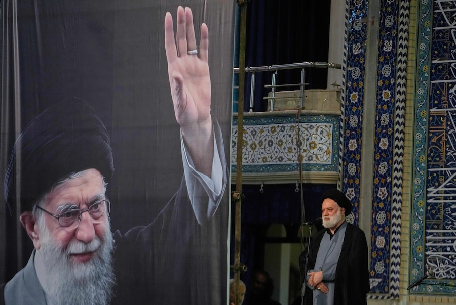 Mostafa, figlio del defunto leader supremo iraniano Ayatollah Ali Khamenei, raffigurato nel banner, interviene durante una cerimonia in memoria del defunto leader presso la Grande Moschea Mosalla dell’Imam Khomeini a Teheran, martedì 14 luglio 2026. (APN)