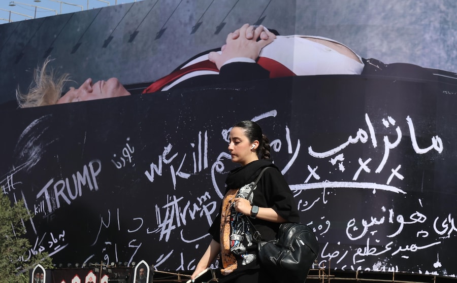 Una donna iraniana cammina davanti a un enorme cartellone pubblicitario che raffigura il presidente degli Stati Uniti Donald Trump in una bara, accompagnato da una frase in persiano che recita: «Uccidiamo Trump», esposto in piazza Enghelab a Teheran, in Iran, il 15 luglio 2026. L’esercito statunitense ha ufficialmente ripristinato il blocco navale contro i porti iraniani e ha effettuato per il quarto giorno consecutivo attacchi mirati alle capacità militari di Teheran, secondo quanto riferito dal Comando Centrale degli Stati Uniti (CENTCOM). (EPA)