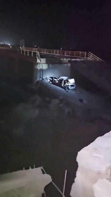 Una luce illumina un veicolo danneggiato e una porzione di ponte crollata in seguito a un attacco a Bandar Khamir, nella provincia di Hormozgan (Iran) (Social Media via REUTERS)