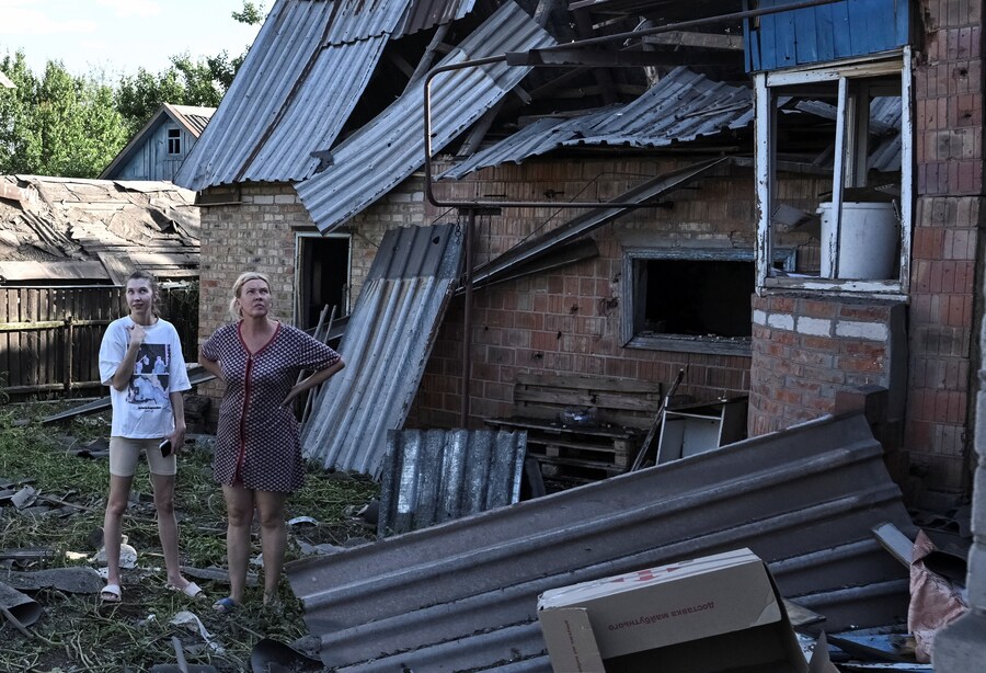 Alcuni residenti si trovano nei pressi della loro casa colpita da un attacco aereo russo, nel contesto dell'offensiva russa contro l'Ucraina, a Zaporizhzhia, Ucraina, il 18 luglio 2026. (REUTERS/Stringer)