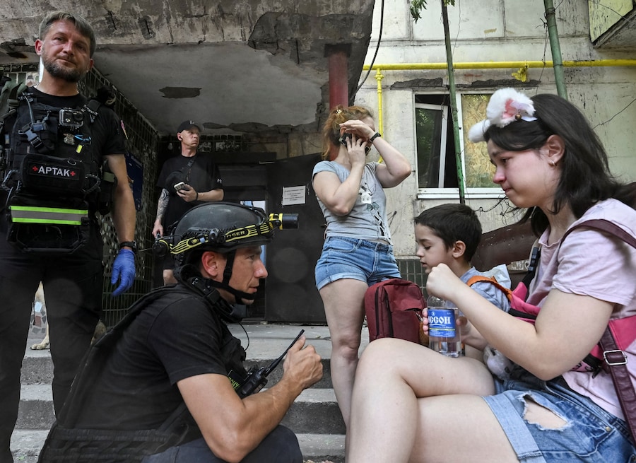Uno psicologo specializzato in situazioni di emergenza parla con alcuni residenti nei pressi di un condominio colpito da un attacco aereo russo, a Zaporizhzhia. (REUTERS/Stringer)