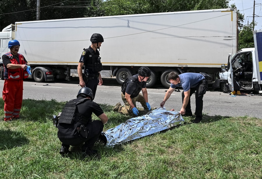 Agenti di polizia accanto al corpo di un residente ucciso sul luogo di un attacco aereo russo, a Zaporizhzhia. (REUTERS/Stringer)