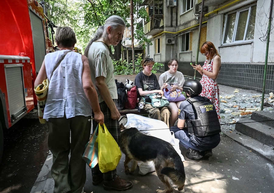 Uno psicologo specializzato in situazioni di emergenza parla con alcuni residenti nei pressi di un condominio colpito da un attacco aereo russo, a Zaporizhzhia. (REUTERS/Stringer)