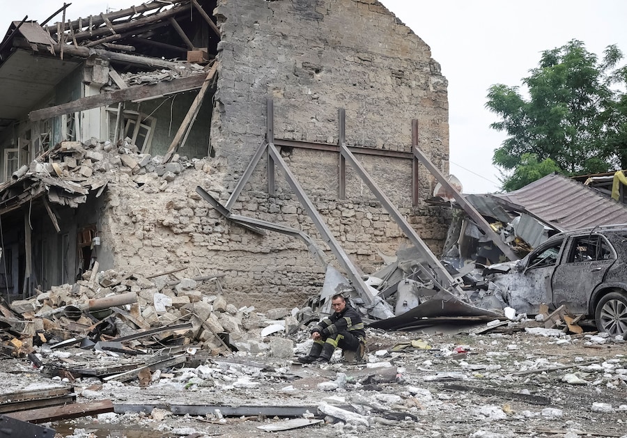 Un soccorritore si riposa sul luogo di un condominio colpito da un missile russo, nel corso dell'attacco della Russia all'Ucraina, a Odessa. (REUTERS)