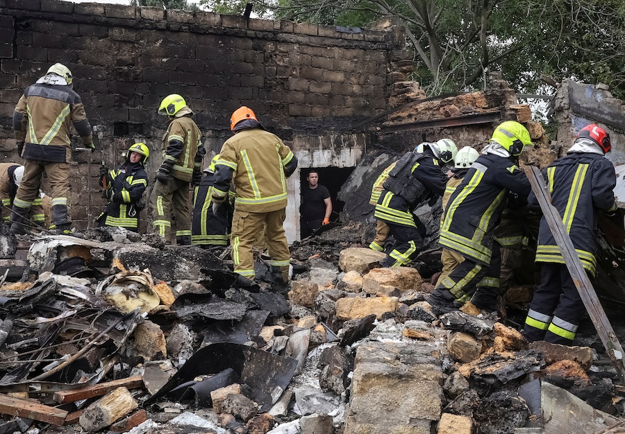 Un residente osserva i soccorritori al lavoro sul luogo di un condominio colpito da un missile russo, nel contesto dell'attacco della Russia all'Ucraina, a Odessa. (REUTERS)