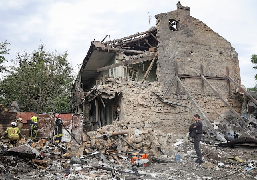 Un residente osserva i soccorritori al lavoro sul luogo di un condominio colpito da un missile russo, nel contesto dell'attacco della Russia all'Ucraina, a Odessa. (REUTERS)