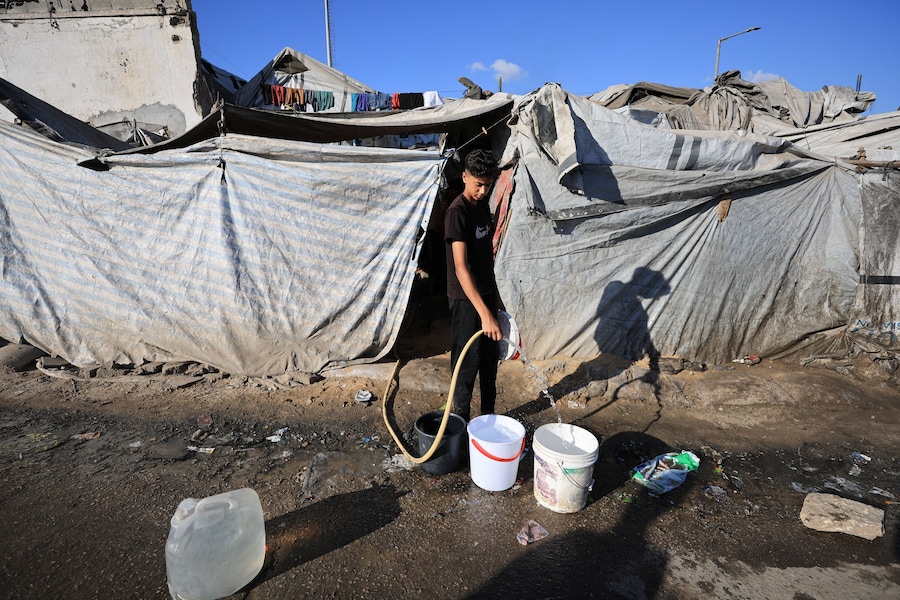 Un uomo riempie dei secchi d'acqua in un accampamento di tende nella città di Gaza, il 26 luglio 2026. REUTERS/Dawoud Abu Alkas (REUTERS)