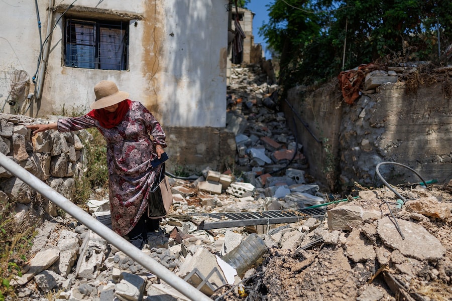 Haifa Shkair, una residente, cammina all’esterno della sua casa danneggiata dopo aver fatto ritorno a Zawtar al-Gharbiyeh, nel Libano meridionale (REUTERS)