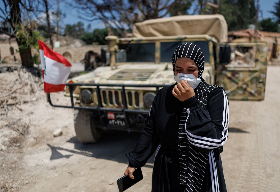 Un residente passa accanto a un veicolo dell’esercito libanese dopo aver fatto ritorno a Zawtar al-Gharbiyeh, un villaggio nel sud del Libano (REUTERS)