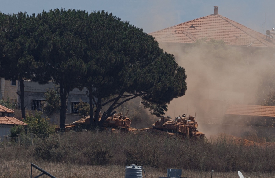 Carri armati dell’esercito israeliano operano a Zawtar al-Charkiya, visti dal villaggio di Zawtar al-Gharbiyeh nel Libano meridionale (REUTERS)