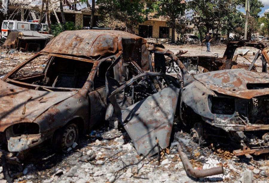 Un residente si trova vicino ad alcune auto danneggiate da un attacco israeliano a Zawtar al-Gharbiyeh, un villaggio nel sud del Libano (REUTERS)