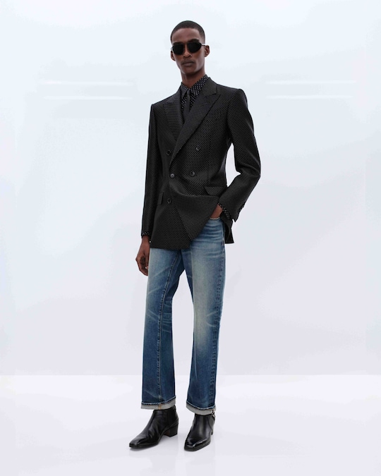 Tom Ford by Haider Ackermann. In jacquard nero a motivo losanga puntinata, camicia fluida stampa geometrica, cravatta in nappa, pantaloni in denim selvedge stretch