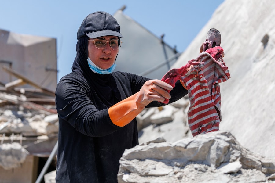 Nour Hamzeh mostra gli effetti personali di un neonato che ha trovato tra le macerie della sua casa, distrutta da un attacco israeliano, e che, ha detto, voleva conservare come ricordo per i suoi figli, dopo essere tornata a Zawtar al-Gharbiyeh, nel sud del Libano, in seguito allo schieramento dei soldati libanesi in una delle tre cosiddette «zone pilota» istituite dopo il ritiro delle forze israeliane nell’ambito di un piano mediato dagli Stati Uniti, il 27 luglio 2026. REUTERS/Zohra Bensemra (REUTERS)