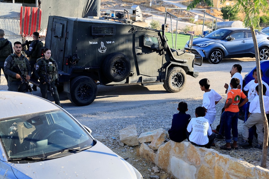 Alcuni ragazzi palestinesi osservano la polizia di frontiera israeliana durante una manifestazione in occasione del primo anniversario della morte dell’attivista palestinese Odeh Hathaleen, a Umm al-Khair, nella Cisgiordania occupata da Israele, il 28 luglio 2026. REUTERS/Mussa Qawasma (REUTERS)