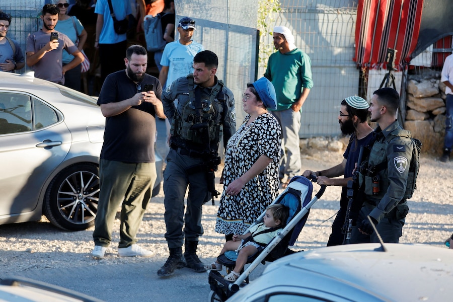 Agenti della polizia di frontiera israeliana scortano alcuni coloni israeliani durante una manifestazione in occasione del primo anniversario della morte dell’attivista palestinese Odeh Hathaleen, a Umm al-Khair, nella Cisgiordania occupata da Israele, il 28 luglio 2026. REUTERS/Mussa Qawasma (REUTERS)