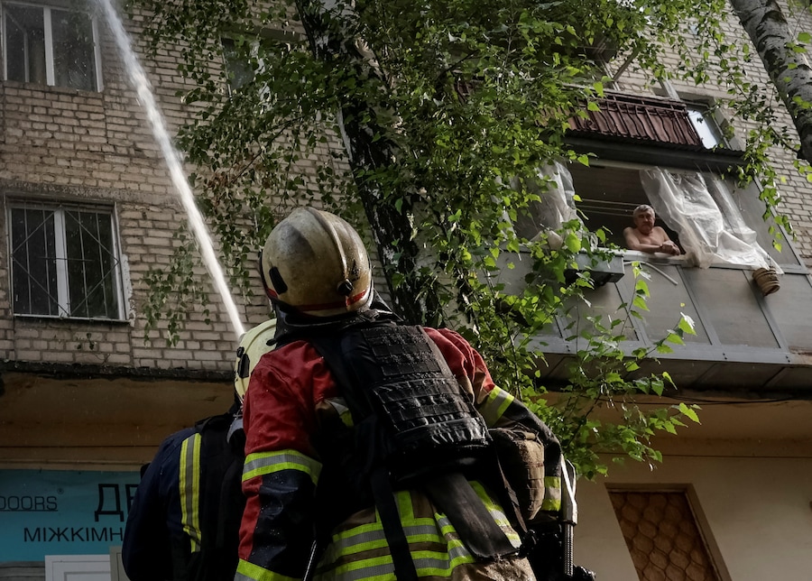 Un residente osserva i vigili del fuoco all'opera sul luogo di un condominio colpito da un attacco con droni russi, nel contesto dell'offensiva russa contro l'Ucraina, nella regione di Kharkiv, Ucraina, il 28 luglio 2026. REUTERS/Sofiia Gatilova (REUTERS)