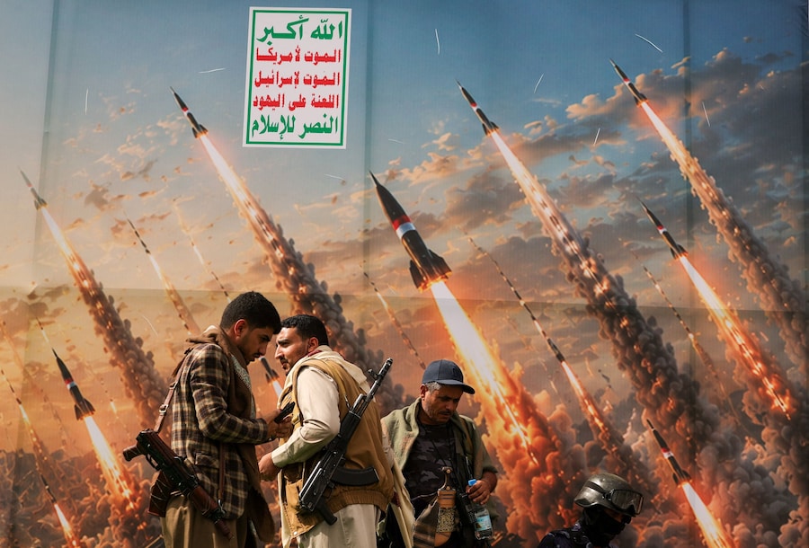 Attivisti Houthi su una pedana davanti a uno striscione che raffigura missili Houthi, durante una manifestazione anti-saudita nel contesto di un’escalation con il Regno, a Sana’a, Yemen (REUTERS)