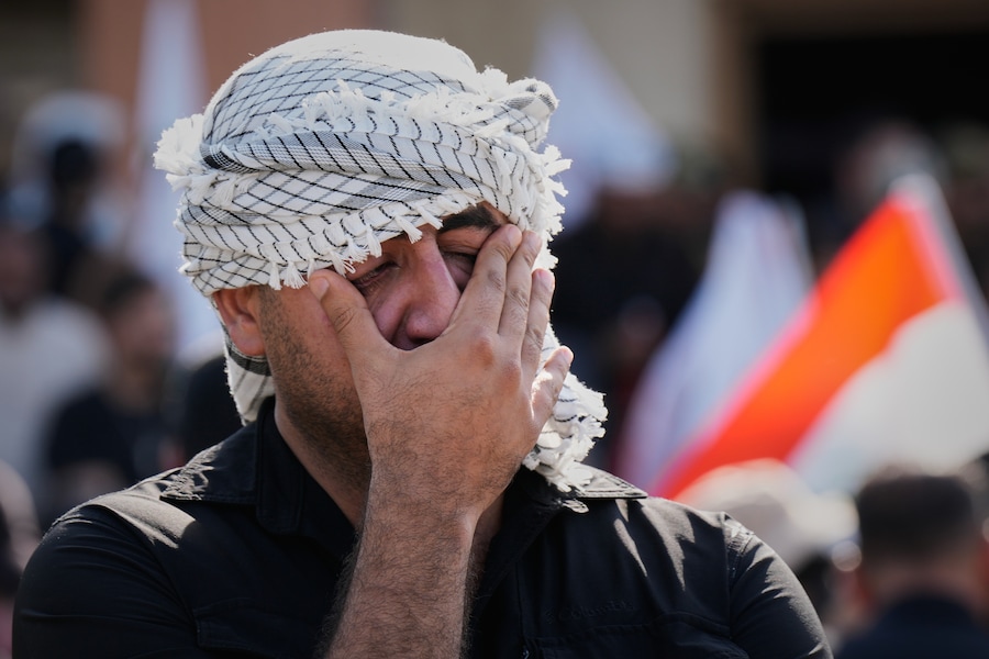 Una persona in lutto piange durante un funerale collettivo per le vittime di attacchi aerei contro basi delle Forze di Mobilitazione Popolare irachene – una coalizione di milizie a prevalenza sciita che comprende gruppi sostenuti dall’Iran – a Mosul, in Iraq (APN)