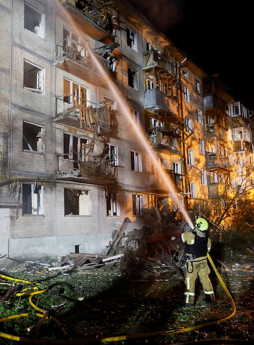 Un vigile del fuoco lavora sul luogo di un condominio colpito da un attacco missilistico russo a Kiev (REUTERS)