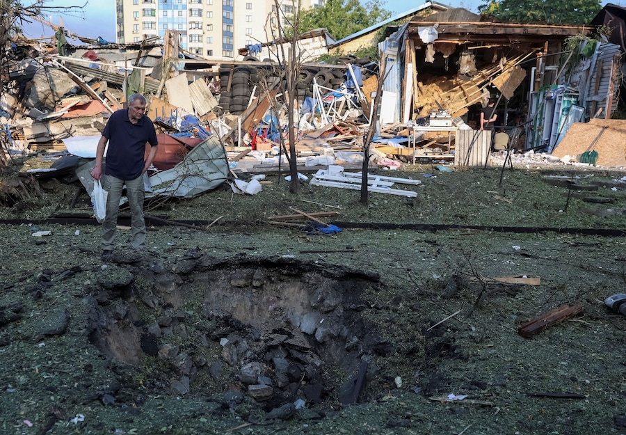Un residente osserva un cratere nel luogo colpito da un missile russo a Kiev (REUTERS)