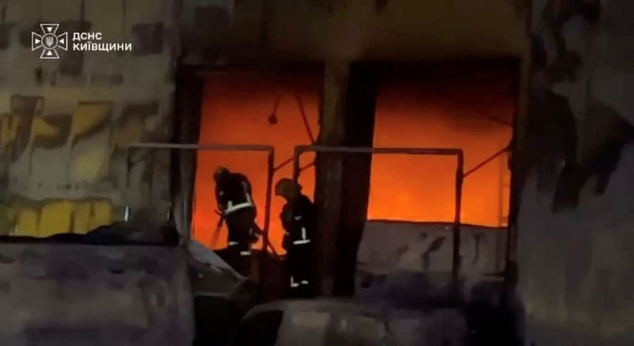 Personale di soccorso è al lavoro sul luogo di un incendio in un magazzino nel distretto di Bucha, nella regione di Kiev (via REUTERS)