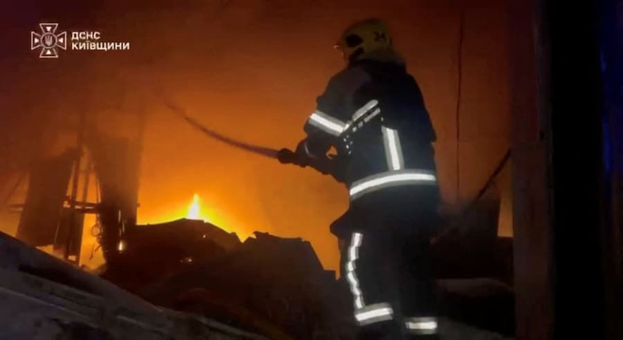 Un soccorritore è al lavoro sul luogo di un incendio in un magazzino nel distretto di Bucha, nella regione di Kiev (Ucraina) (via REUTERS)