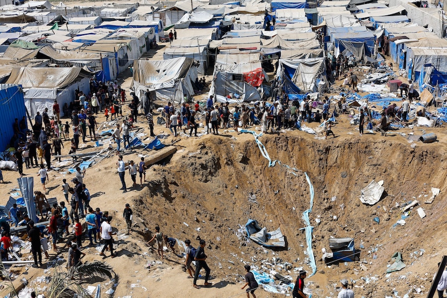 Alcuni palestinesi ispezionano il luogo colpito durante la notte da un attacco israeliano contro un deposito di medicinali – situato, secondo il personale sanitario, accanto a tende che ospitano palestinesi sfollati – a Deir al-Balah, nella Striscia di Gaza centrale (REUTERS)
