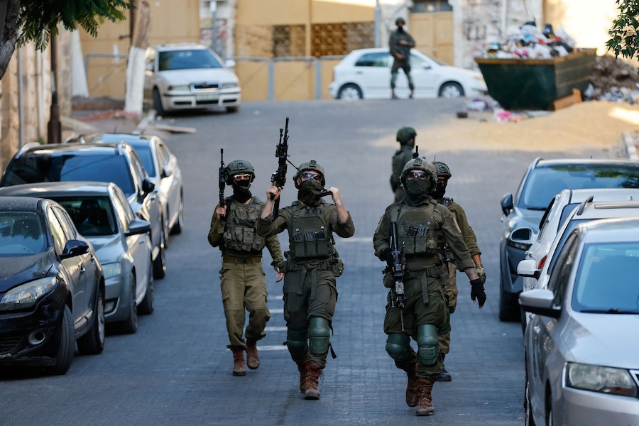 Soldati israeliani pattugliano l’area e vigilano durante il tour settimanale dei coloni israeliani a Hebron, in Cisgiordania sotto occupazione israeliana (REUTERS)