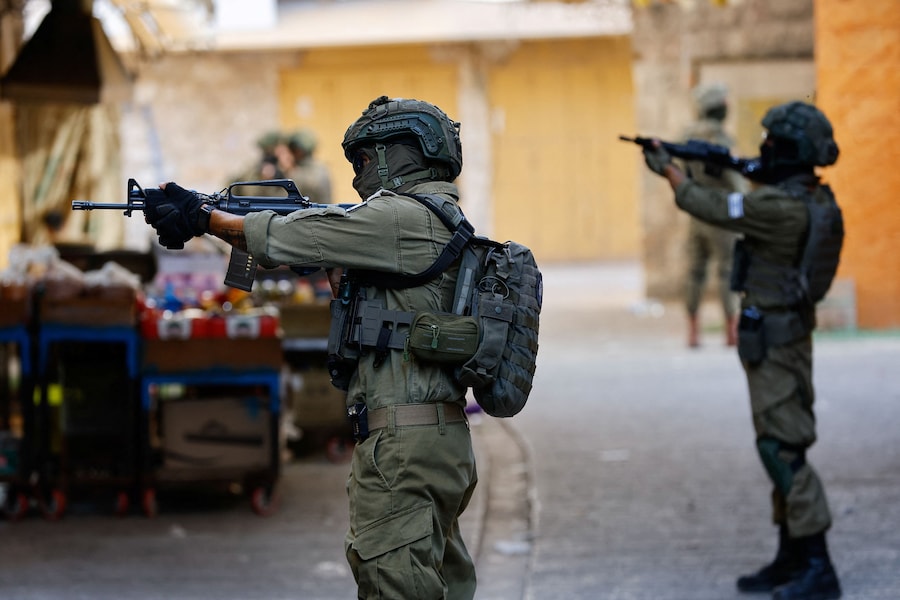 Soldati israeliani pattugliano l’area e vigilano durante il tour settimanale dei coloni israeliani a Hebron, in Cisgiordania sotto occupazione israeliana (REUTERS)