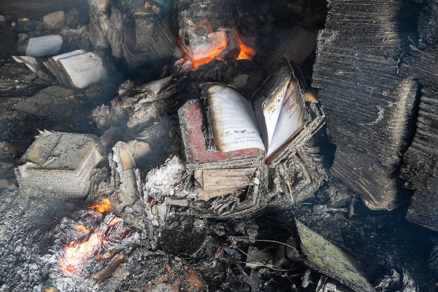 Dei libri bruciano in un grande magazzino librario a seguito di attacchi con droni russi a Kharkiv, in Ucraina (APN)