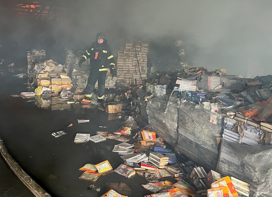 Un vigile del fuoco opera sul luogo di un magazzino di libri colpito da un attacco di droni russi a Kharkiv (REUTERS)