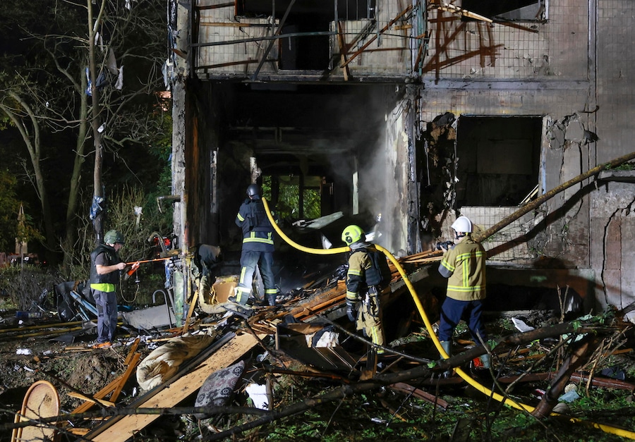 Soccorritori al lavoro sul luogo colpito da un missile russo contro un edificio residenziale a Kiev (EPA)