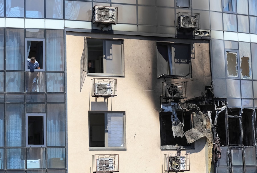 Un residente guarda fuori dalla finestra di un condominio danneggiato da un attacco di droni russi a Odessa, Ucraina (REUTERS)