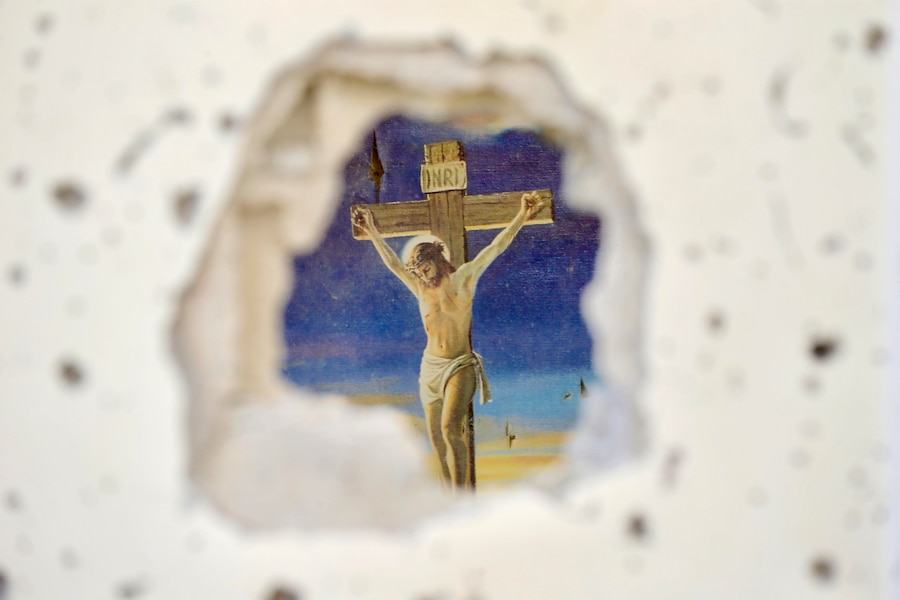 Un dipinto raffigurante la Passione di Cristo mentre alcuni volontari rimuovono detriti e macerie all’interno di una chiesa distrutta dai bombardamenti aerei israeliani nel villaggio di Zawtar al-Gharbiyah, nella provincia di Nabatieh, nel Libano meridionale. (EPA/Stringer)