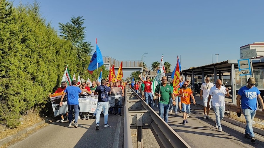 Sciopero di otto ore per ogni turno oggi all'ex Ilva di Taranto dopo il decreto della Corte d'Appello di Milano che ha disposto lo stop dell'area a caldo dello stabilimento siderurgico entro il 28 ottobre e alla vigilia del tavolo tecnico al Mimit. Dopo le due ore di assemblea nell'area antistante il consiglio di fabbrica in cui i coordinatori di Fim, Fiom, Uilm e Usb hanno illustrato lo stato della vertenza e i motivi della mobilitazione, i lavoratori in corteo hanno raggiunto la statale 100 per occupare temporaneamente la strada in corrispondenza della direzione, Taranto 3 agosto 2026. ANSA/ANGELO INGENITO (ANSA)