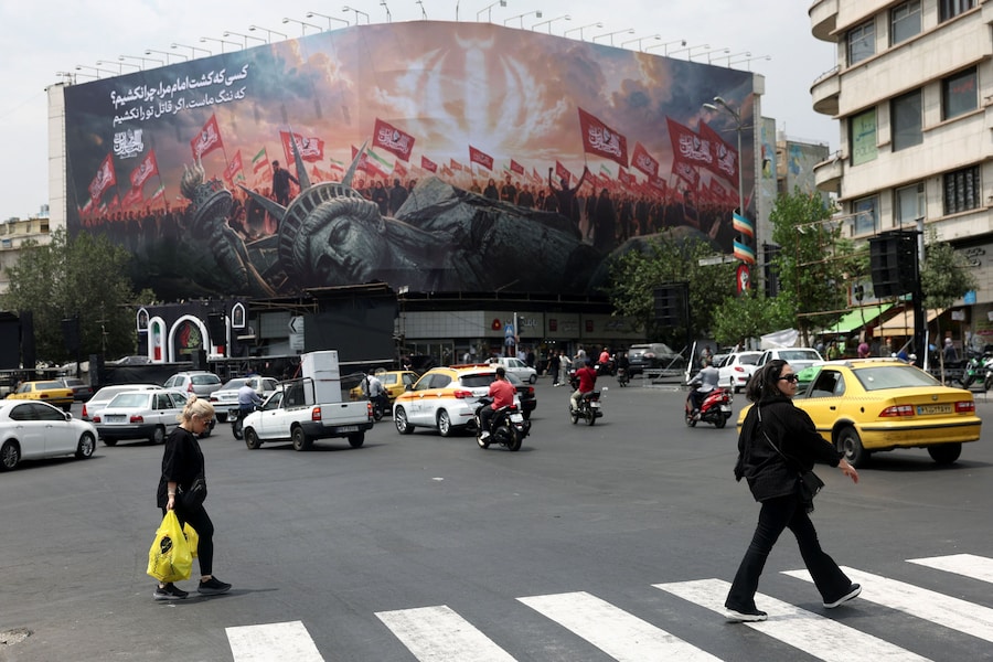 La gente passa davanti a un cartellone pubblicitario anti-statunitense in una strada di Teheran, in Iran. (Majid Asgaripour/WANA (West Asia News Agency) via REUTERS)
