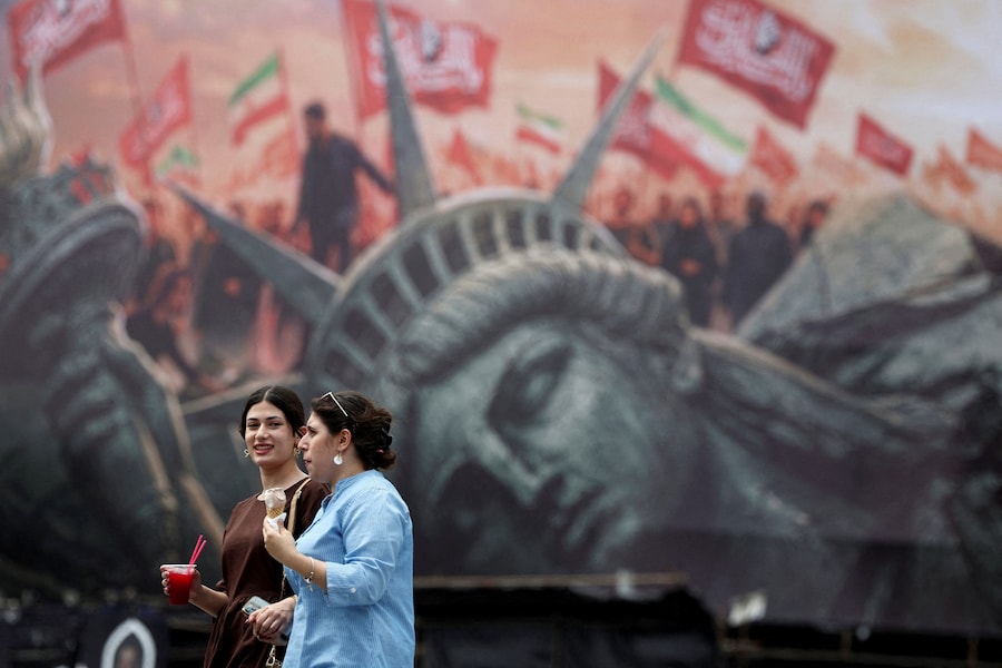 La gente passa davanti a un cartellone pubblicitario anti-statunitense in una strada di Teheran, in Iran. (Majid Asgaripour/WANA (West Asia News Agency) via REUTERS)