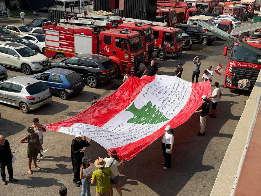 La gente sventola la bandiera libanese e sfila in memoria delle vittime dell’esplosione del porto di Beirut del 2020, Beirut. Il Libano commemora i sei anni dall’esplosione che il 4 agosto 2020 ha devastato l’area portuale di Beirut, causando la morte di almeno 200 persone e il ferimento di altre migliaia. Si ritiene che l’esplosione sia stata causata dall’accensione di circa 2.750 tonnellate di nitrato di ammonio stoccate in un magazzino del porto. (EPA/Abbas Soliman)