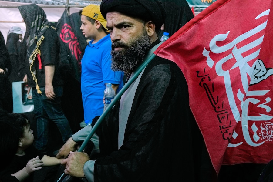 Un religioso porta una bandiera mentre sfila durante i rituali dell’Arbaeen, che si tengono 40 giorni dopo l’Ashura, in commemorazione dell’uccisione del nipote del Profeta Maometto, l’Imam Hussein, e dei membri della sua famiglia nella battaglia di Karbala del 680 d.C., a Teheran. (Foto AP/Vahid Salemi/APN)