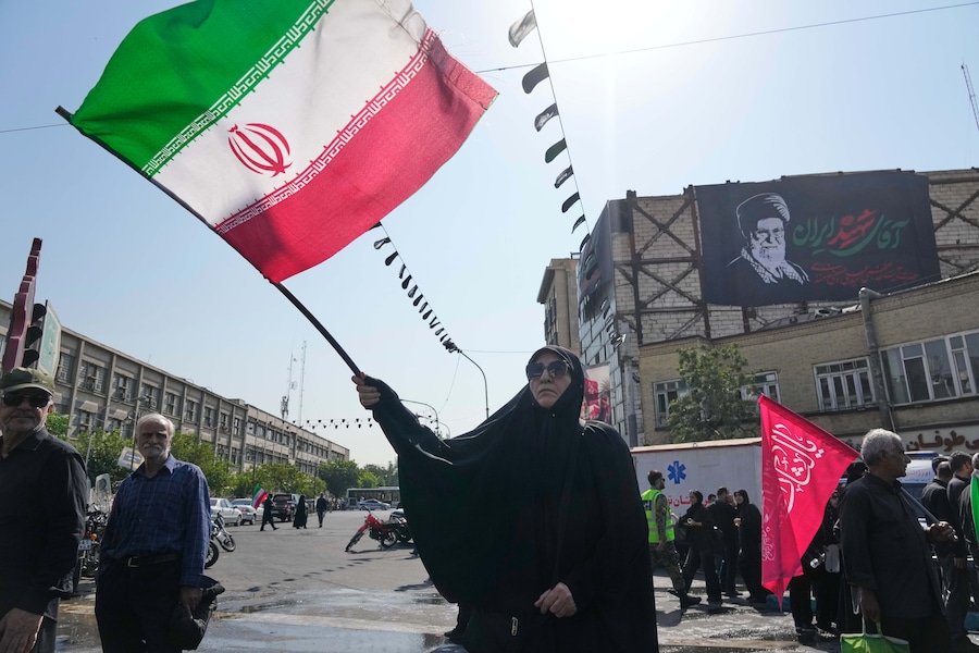 Una donna sventola una bandiera iraniana mentre sullo sfondo si vede uno striscione con il ritratto del defunto Leader Supremo, l’Ayatollah Ali Khamenei, durante i rituali dell’Arbaeen, che si svolgono 40 giorni dopo l’Ashura, in commemorazione dell’uccisione del nipote del Profeta Maometto, l’Imam Hussein, e dei membri della sua famiglia nella battaglia di Karbala nel 680 d.C., a Teheran. (Foto AP/Vahid Salemi/APN)
