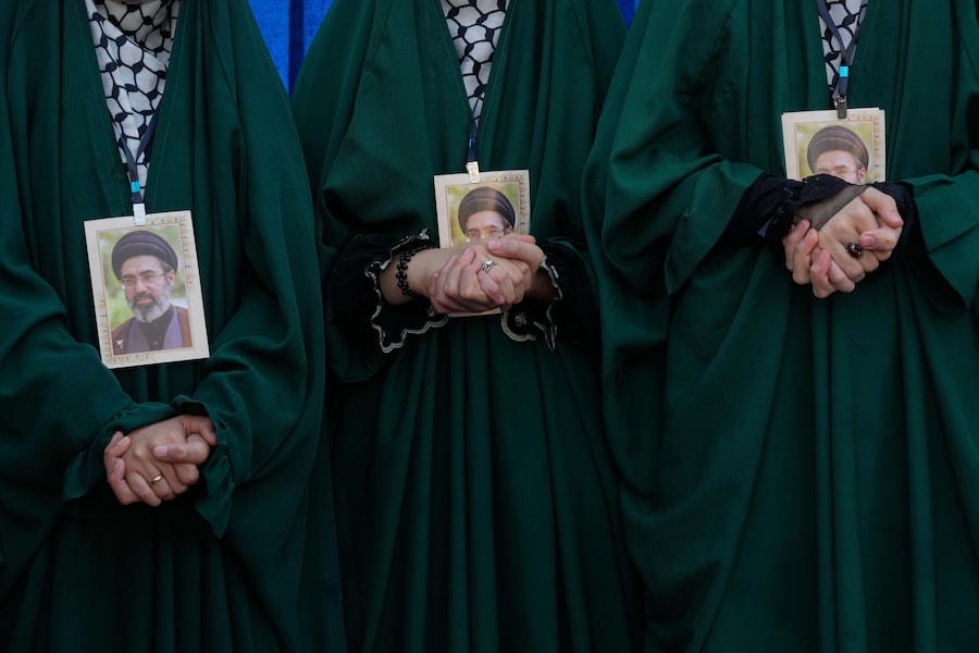 Alcune ragazze iraniane con ritratti della Guida Suprema, l’Ayatollah Mojtaba Khamenei, attendono di intonare un canto durante i rituali dell’Arbaeen, che si svolgono 40 giorni dopo l’Ashura, in commemorazione dell’uccisione del nipote del Profeta Maometto, l’Imam Hussein, e dei membri della sua famiglia nella battaglia di Karbala nel 680 d.C., a Teheran, in Iran. (AP Photo/Vahid Salemi/APN)