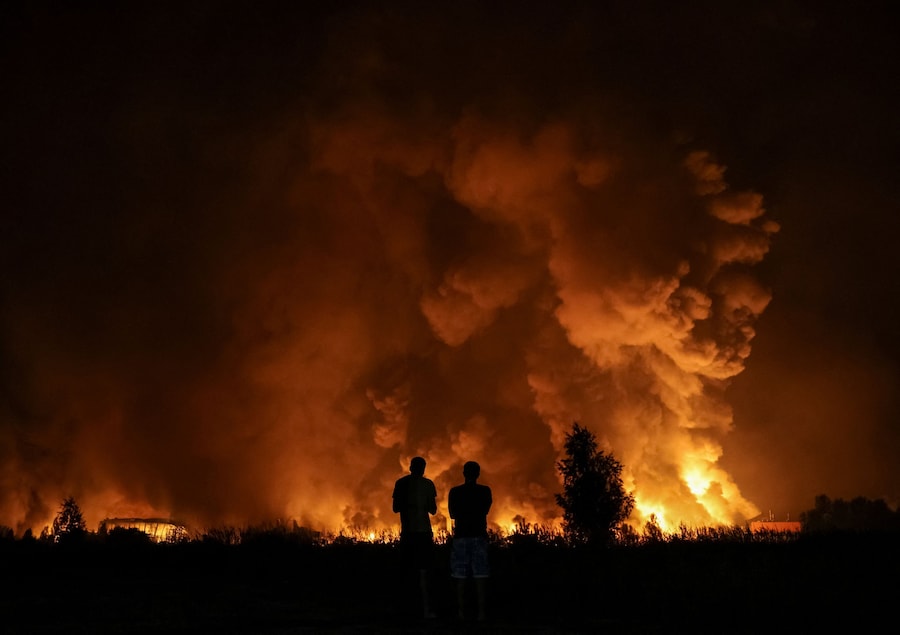 Alcuni residenti osservano il luogo colpito da un missile russo, nella regione di Kiev, Ucraina, il 5 agosto 2026. (REUTERS/Anatolii Stepanov)