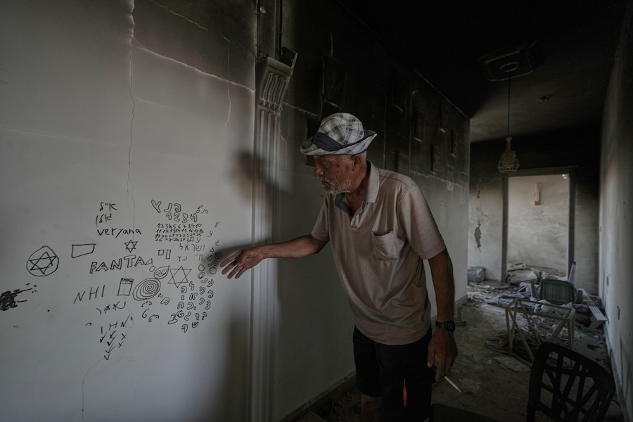 Un uomo libanese indica una scritta in ebraico lasciata dai soldati israeliani all’interno della sua casa distrutta nel villaggio di Zawtar al-Gharbieh, nel sud del Libano. (APN)