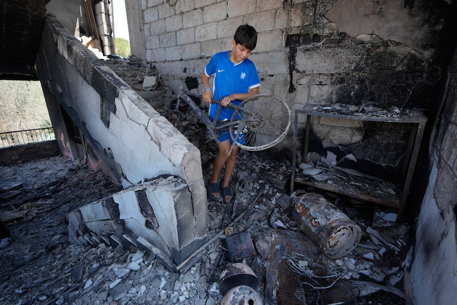 Mercoledì 5 agosto 2026, un ragazzino libanese rimuove parte della sua bicicletta danneggiata dalla sua casa distrutta nel villaggio di Zawtar al-Gharbieh. (APN)