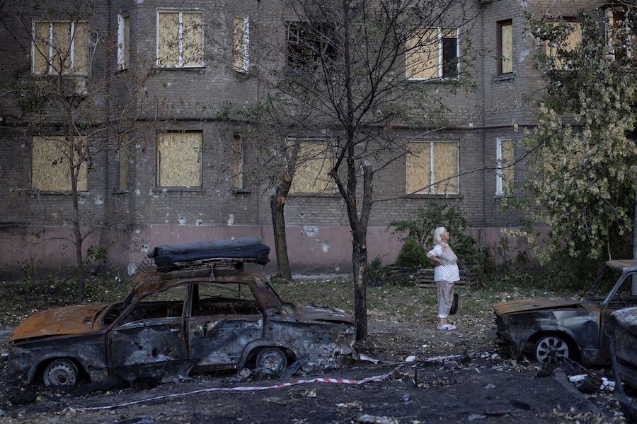 Una donna osserva la devastazione circostante mentre si trova in mezzo a un gruppo di auto carbonizzate, andate a fuoco durante un recente attacco russo, sparse in una zona residenziale, nel contesto dell’offensiva russa contro l’Ucraina, a Zaporizhzhia. (REUTERS)