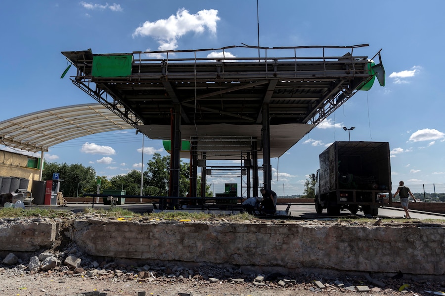 Alcuni uomini lavorano in una stazione di servizio colpita durante un recente attacco russo, nel contesto dell'offensiva russa contro l'Ucraina, a Zaporizhzhia. (REUTERS)