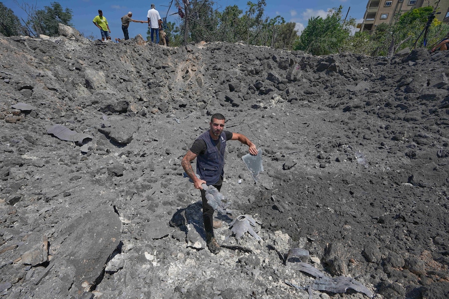 Un uomo libanese tiene in mano alcuni frammenti di schegge mentre si trova all’interno di un grande cratere causato da un attacco aereo israeliano nel villaggio di Burj al-Shamali, nel sud del Libano, giovedì 6 agosto 2026. (Foto AP/Mohammed Zaatari) (APN)