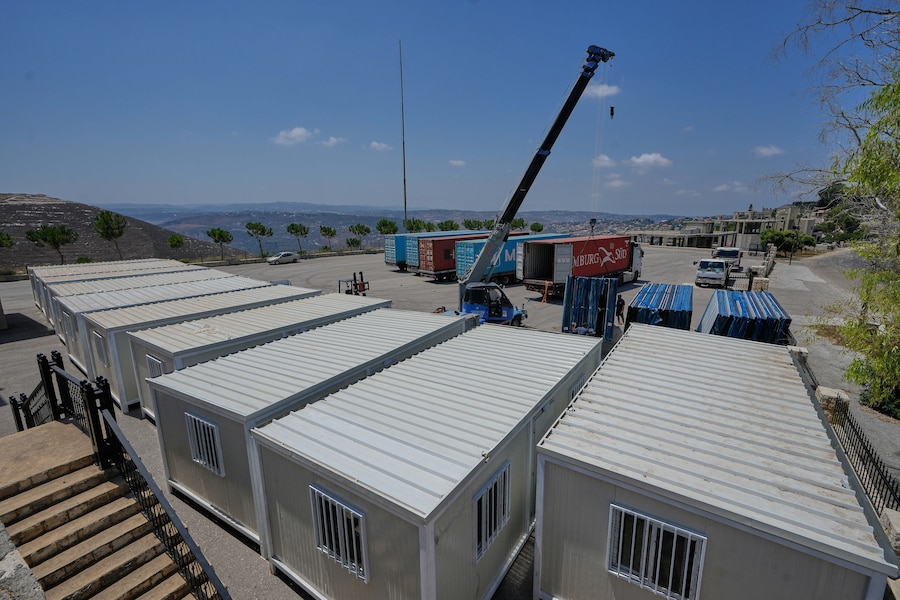 Venerdì 7 agosto 2026, nel villaggio di Zawtar al-Gharbieh, nel sud del Libano, alcuni operai utilizzano una gru per montare case prefabbricate destinate ai residenti le cui abitazioni sono state distrutte durante la guerra tra Israele e Hezbollah. (AP Photo/Mohammed Zaatari) (APN)